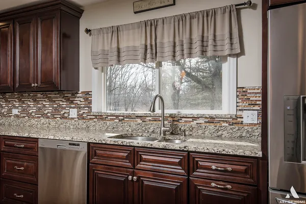 a view of a kitchen with granite countertop a sink and a window