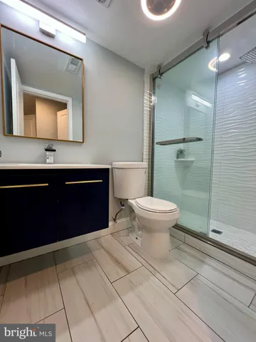 a bathroom with a toilet a sink and mirror