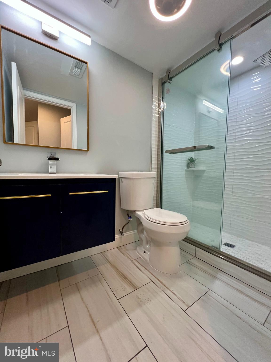 1703 South 22nd Street, Unit 1 Philadelphia, PA 19145 - Photo 18 of 27 a bathroom with a toilet sink and mirror