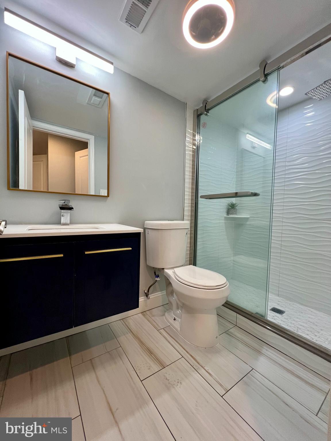 1703 South 22nd Street, Unit 1 Philadelphia, PA 19145 - Photo 19 of 27 a bathroom with a toilet a sink and mirror