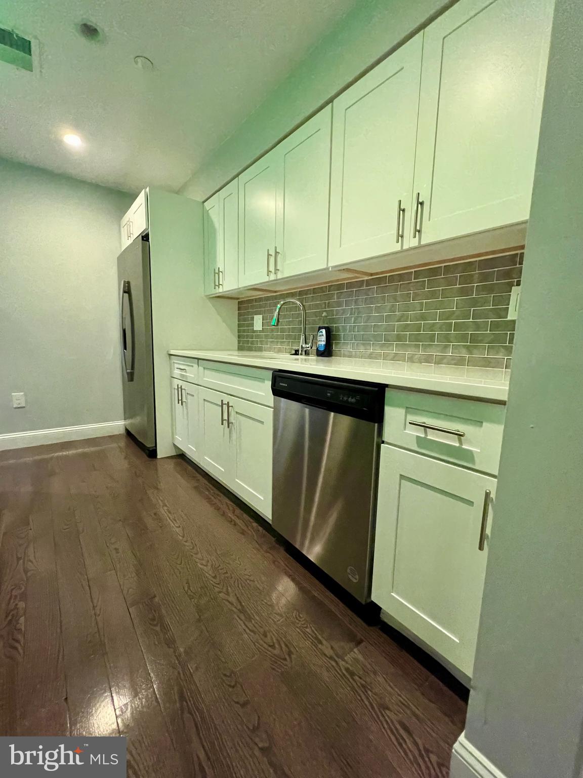 1703 South 22nd Street, Unit 1 Philadelphia, PA 19145 - Photo 8 of 27 a kitchen with granite countertop white cabinets and white appliances