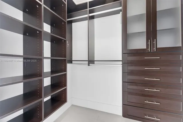 a view of walk in closet with empty racks