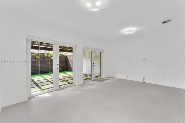 an empty room with floor to ceiling window and an outdoor view