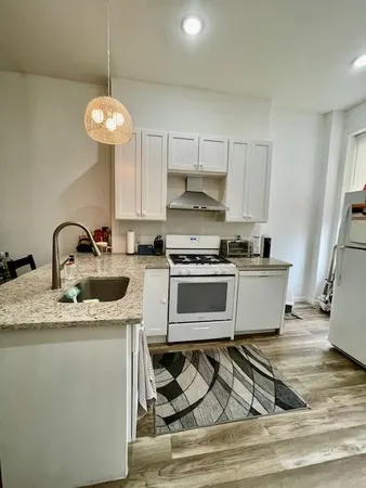 a kitchen with stainless steel appliances granite countertop a sink a stove a refrigerator and cabinets