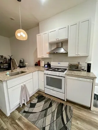 a kitchen with a stove window and cabinets
