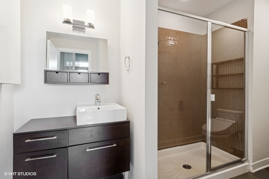 660 West Wayman Street, Unit 701 Chicago, IL 60661 - Photo 8 of 23 a bathroom with a sink a mirror and shower