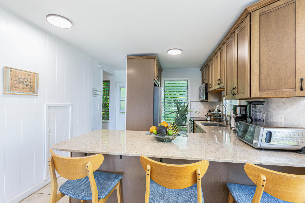 380 Papaloa Road, Unit 2 Kapaa, HI 96746 - Photo 10 of 20 a kitchen with stainless steel appliances granite countertop sink cabinets and wooden floor
