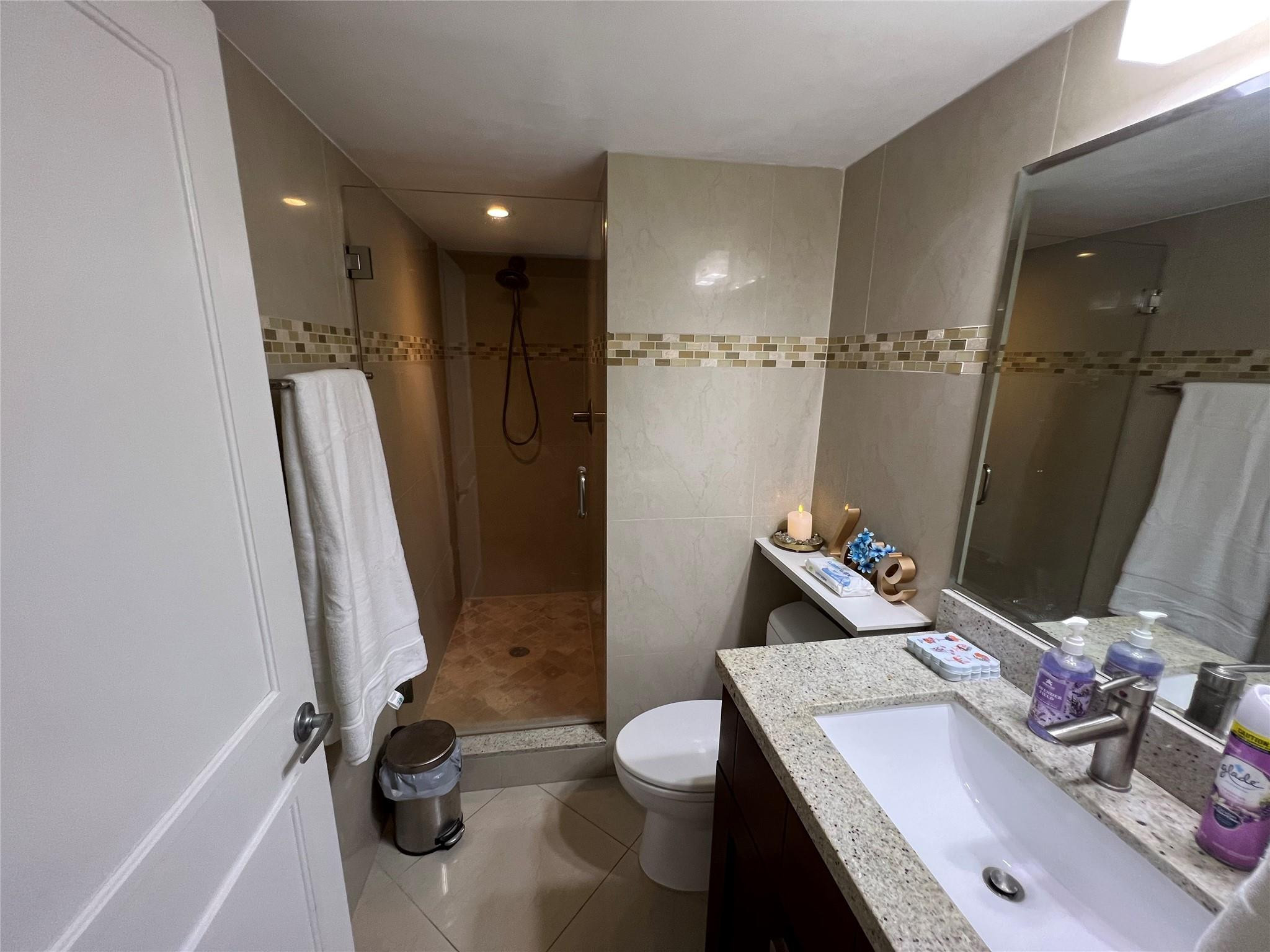 9300 Southwest 8th Street, Unit 108 Boca Raton, FL 33428 - Photo 23 of 40 a bathroom with a sink a toilet and shower