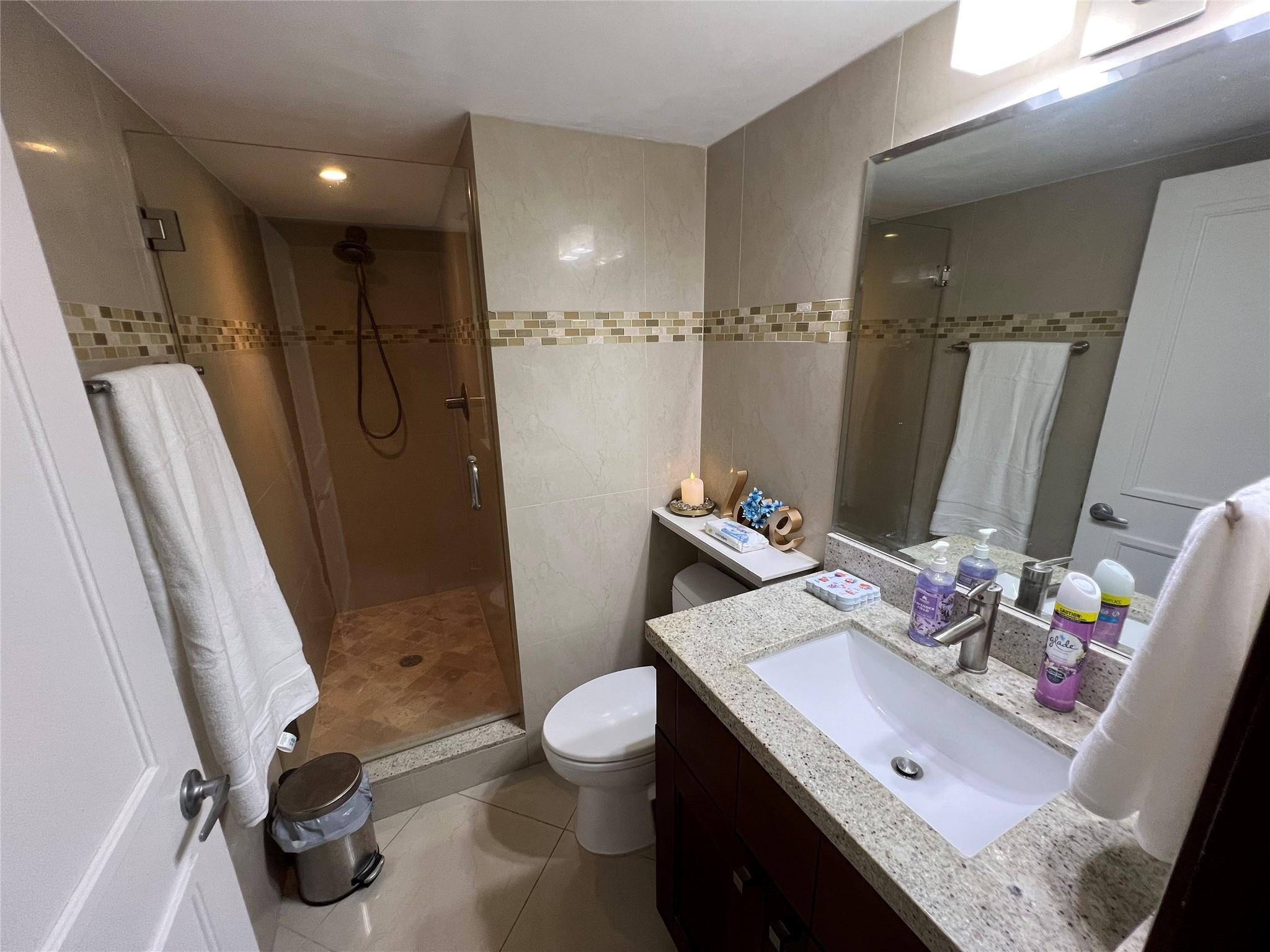 9300 Southwest 8th Street, Unit 108 Boca Raton, FL 33428 - Photo 25 of 40 a bathroom with a sink a toilet and shower