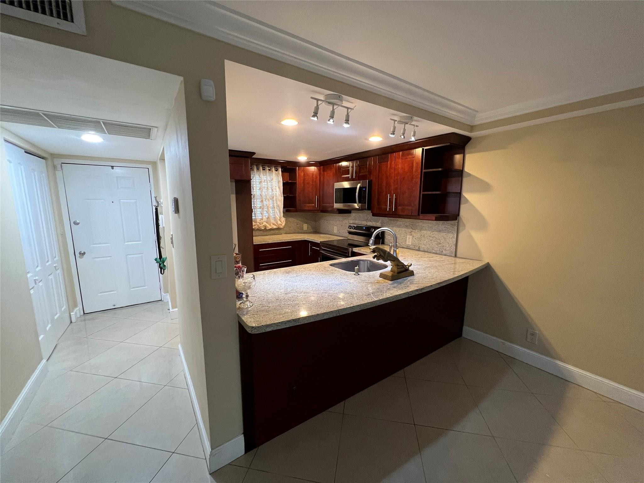 9300 Southwest 8th Street, Unit 108 Boca Raton, FL 33428 - Photo 27 of 40 a kitchen with a sink and a refrigerator