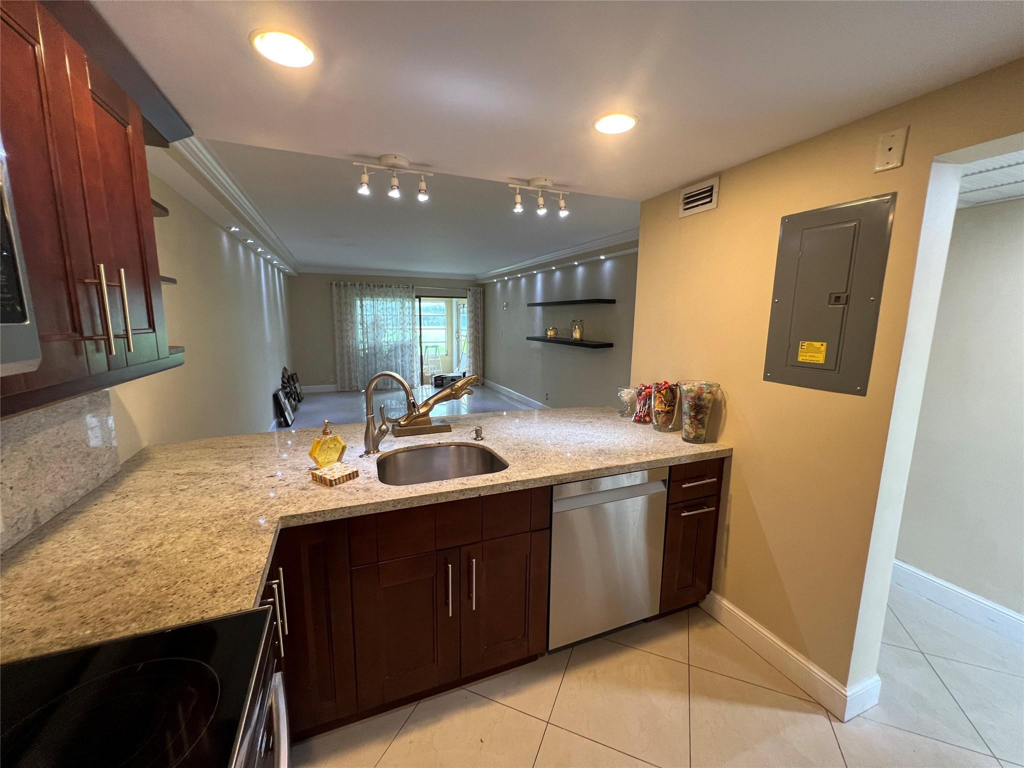 9300 Southwest 8th Street, Unit 108 Boca Raton, FL 33428 - Photo 36 of 40 a kitchen with stainless steel appliances granite countertop a sink and a refrigerator