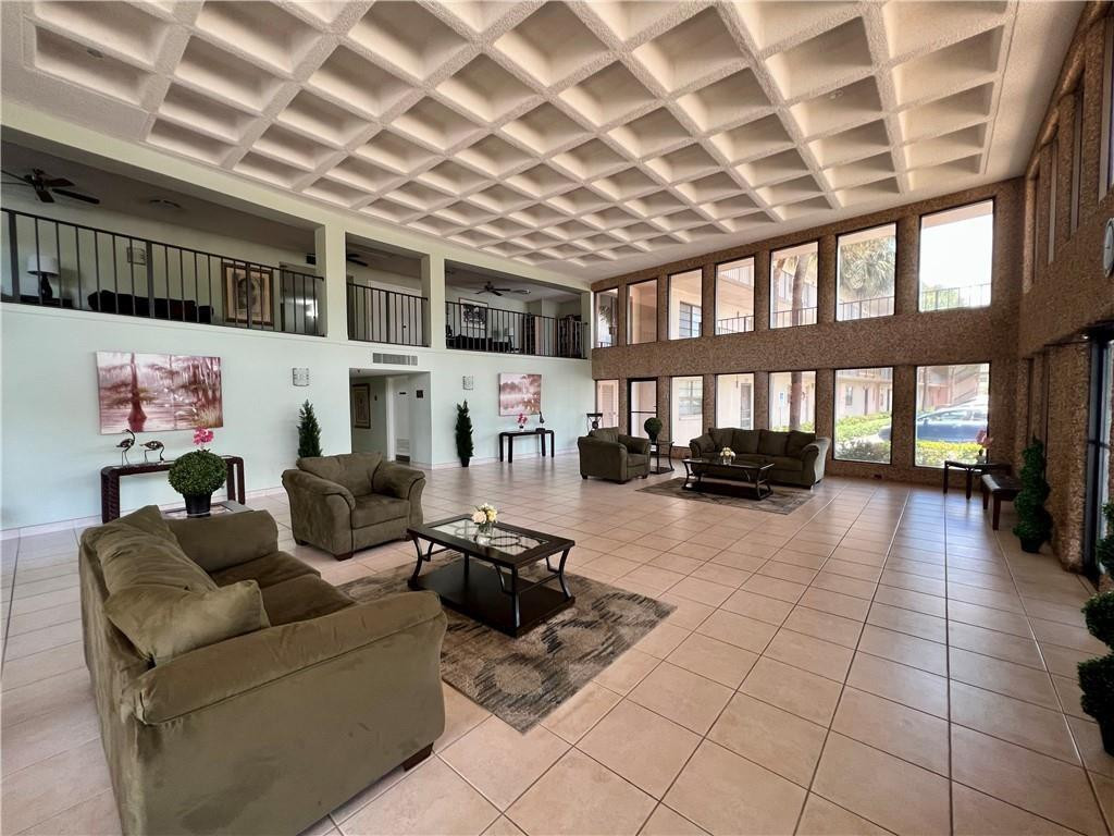 9300 Southwest 8th Street, Unit 108 Boca Raton, FL 33428 - Photo 4 of 40 a living room with furniture and a floor to ceiling window