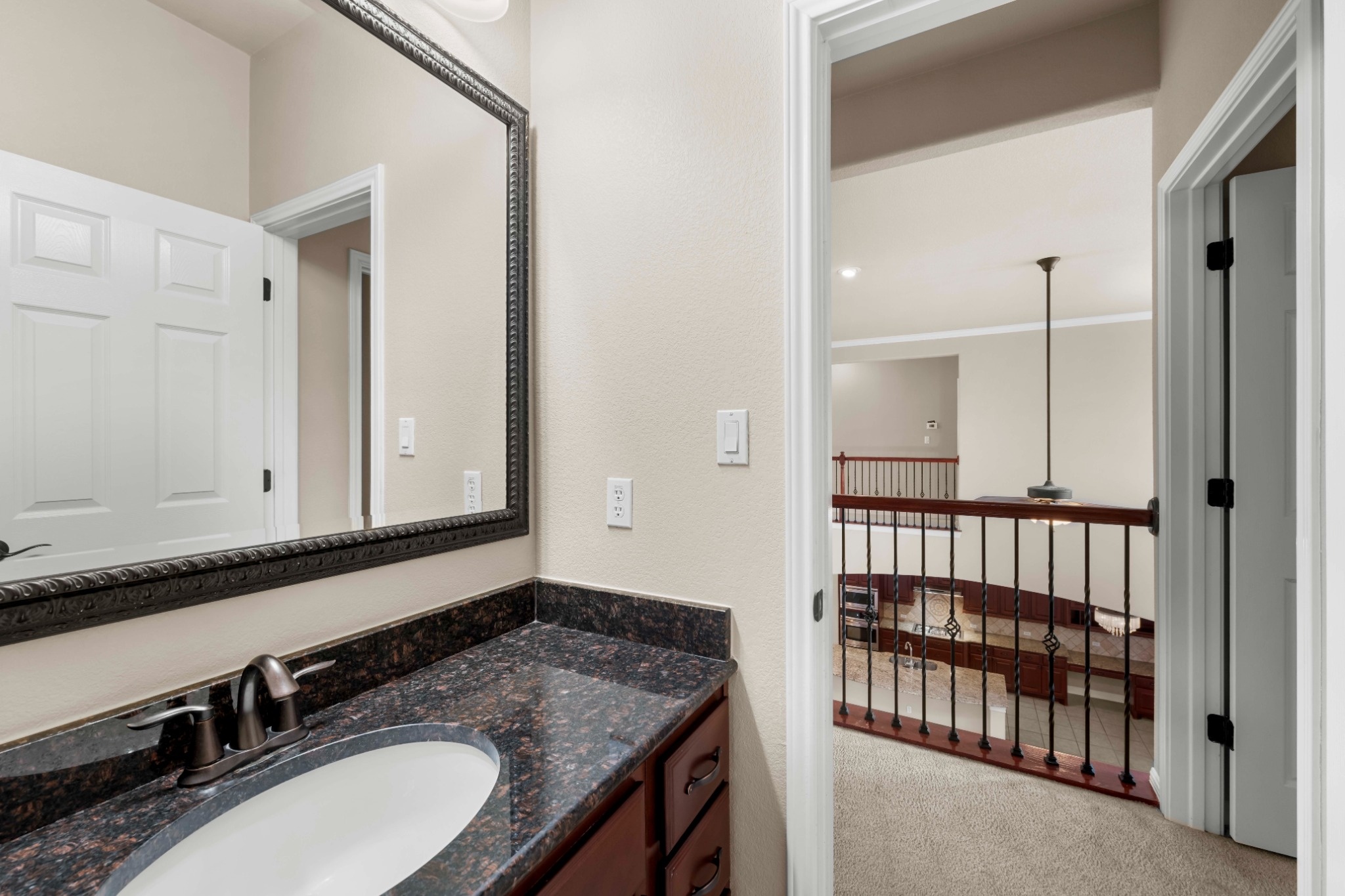3903 Remington Road Cedar Park, TX 78613 - Photo 26 of 29 Granite counters and dark wood cabinetry define this well-appointed bathroom vanity.
