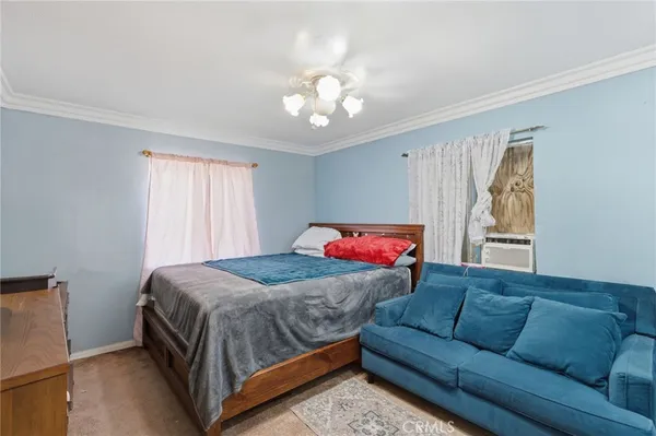 a bedroom with a bed couch and window