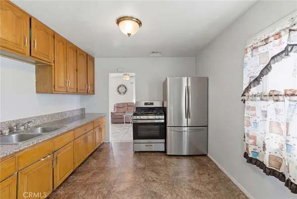 a kitchen with stainless steel appliances granite countertop a refrigerator a stove a sink and a microwave