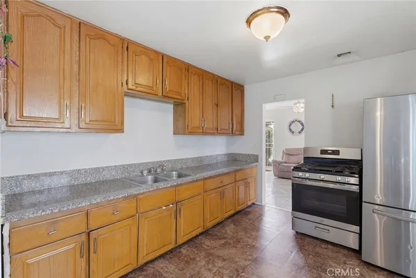 a kitchen with stainless steel appliances granite countertop a stove a sink and a refrigerator