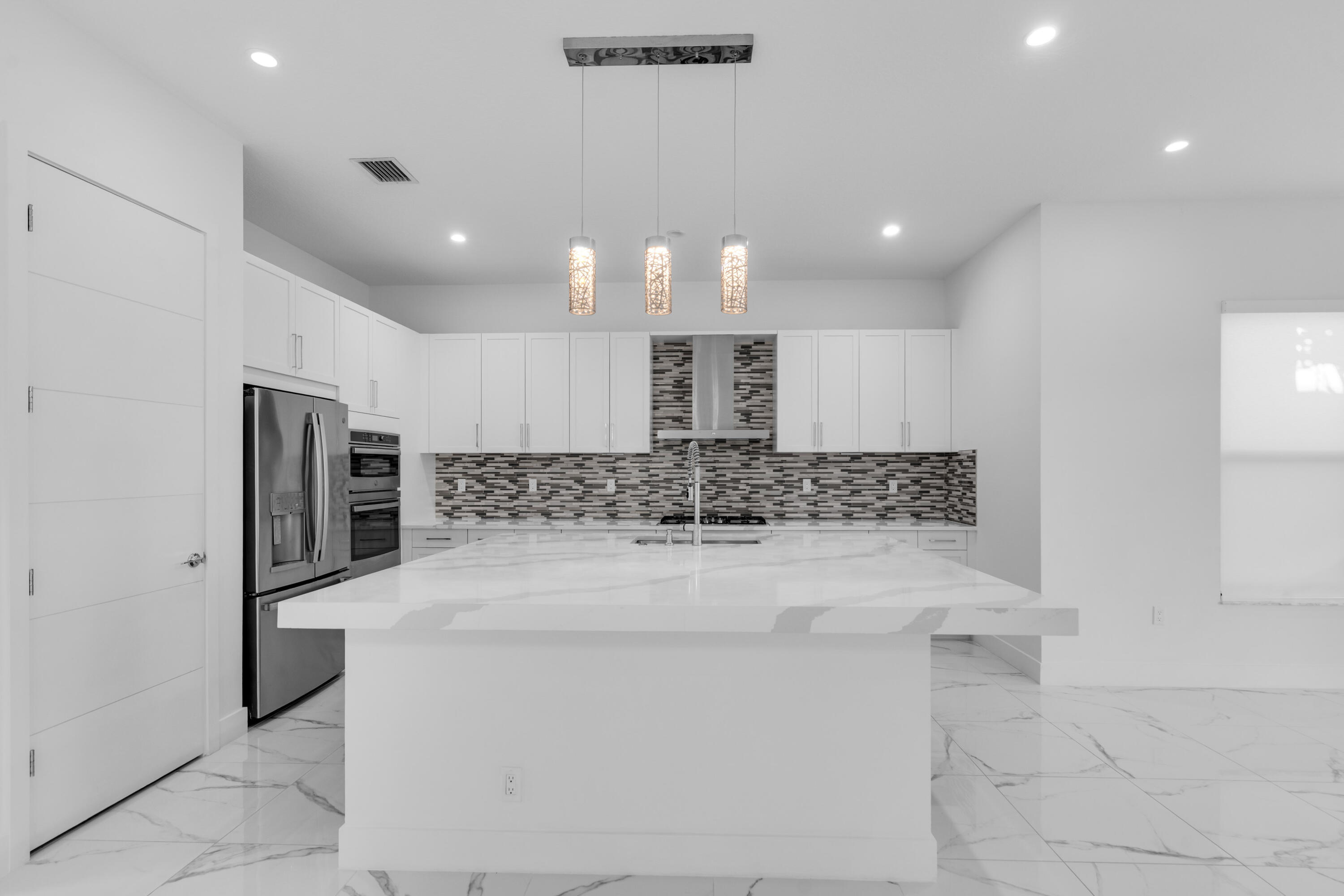 8281 Oceanus Drive Boca Raton, FL 33496 - Photo 44 of 52 a large kitchen with stainless steel appliances kitchen island a large counter top and a refrigerator