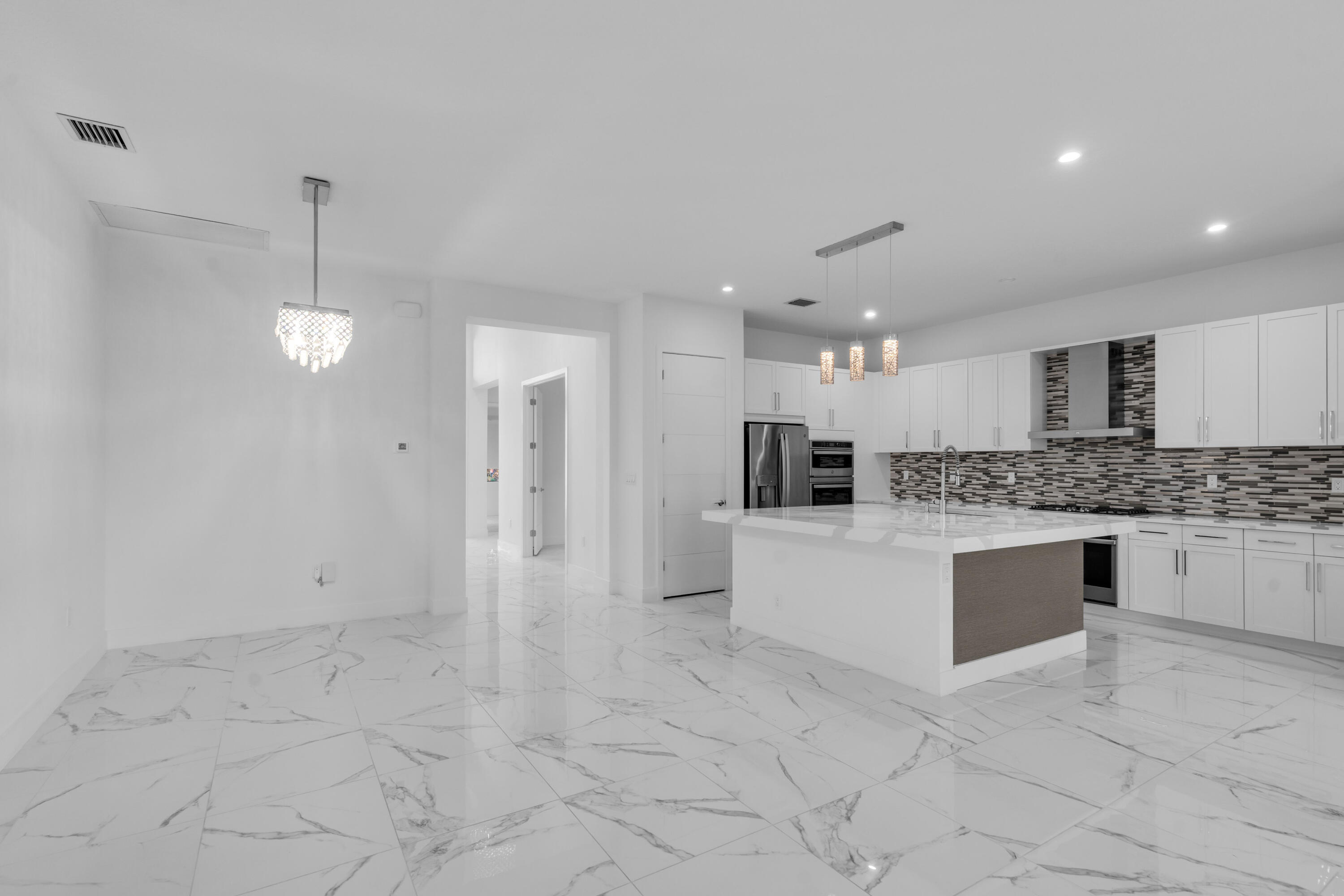 8281 Oceanus Drive Boca Raton, FL 33496 - Photo 45 of 52 a large white kitchen with a white cabinets