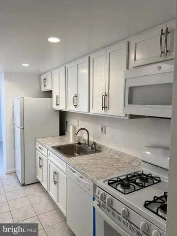 a kitchen with granite countertop stainless steel appliances a sink a stove and cabinets