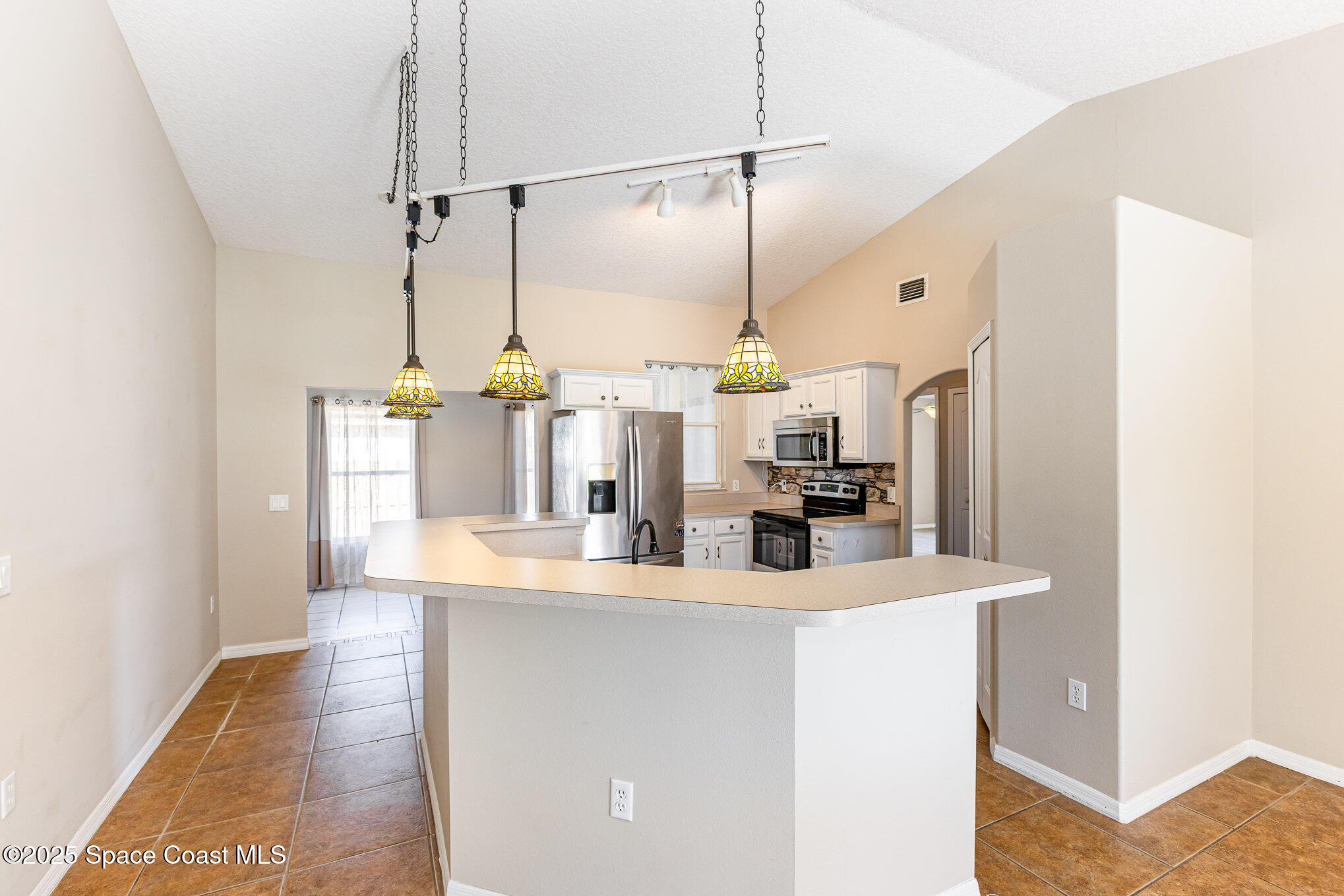 6480 Annapolis Street Cocoa, FL 32927 - Photo 7 of 30 a kitchen with kitchen island a sink a counter space and stainless steel appliances