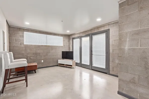 a living room with furniture a flat screen tv and a window