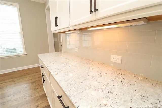 a view of a kitchen with wooden floor and a window