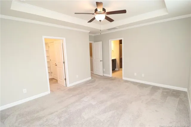 an empty room with closet and a ceiling fan