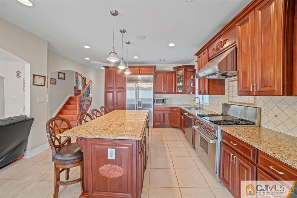 191 West Northfield Road Livingston, NJ 07039 - Photo 8 of 22 a kitchen with stainless steel appliances granite countertop a stove a sink dishwasher and a refrigerator with wooden cabinets