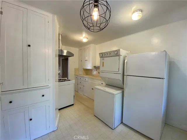 a kitchen with appliances a refrigerator and a stove top oven