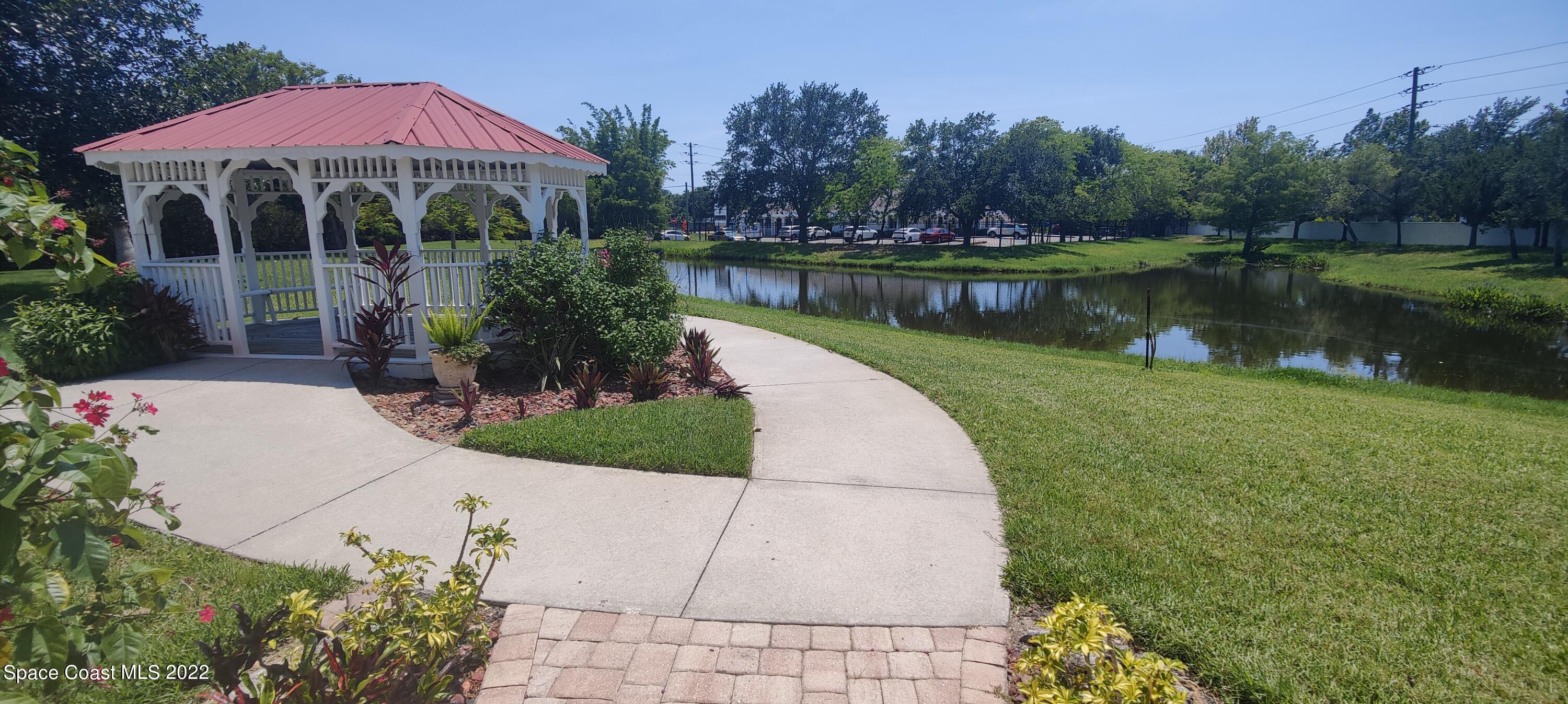 820 Del Rio Way, Unit 204 Merritt Island, FL 32953 - Photo 55 of 72 a view of a lake with a house in the background