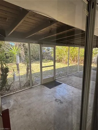 a view of empty room with wooden floor and floor to ceiling window