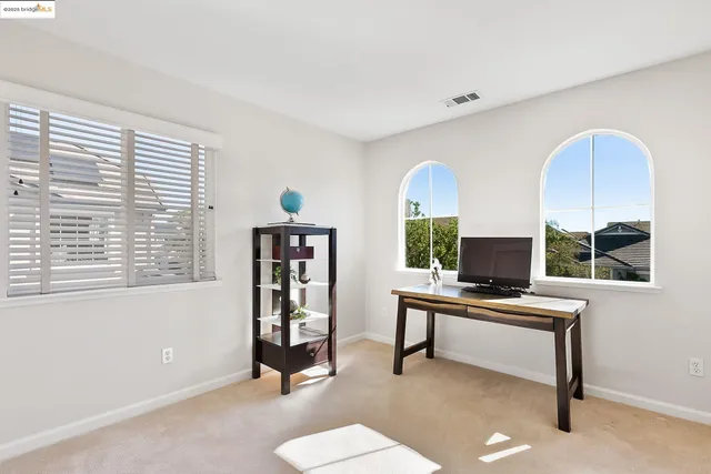 a view of a workspace with furniture and a window