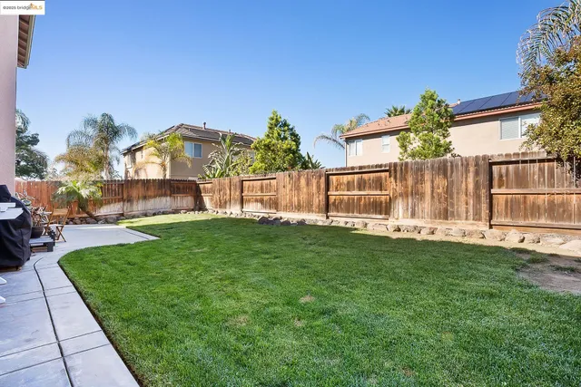 a backyard of a house with table and chairs