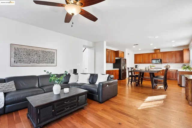 a living room with furniture kitchen view and a potted plant