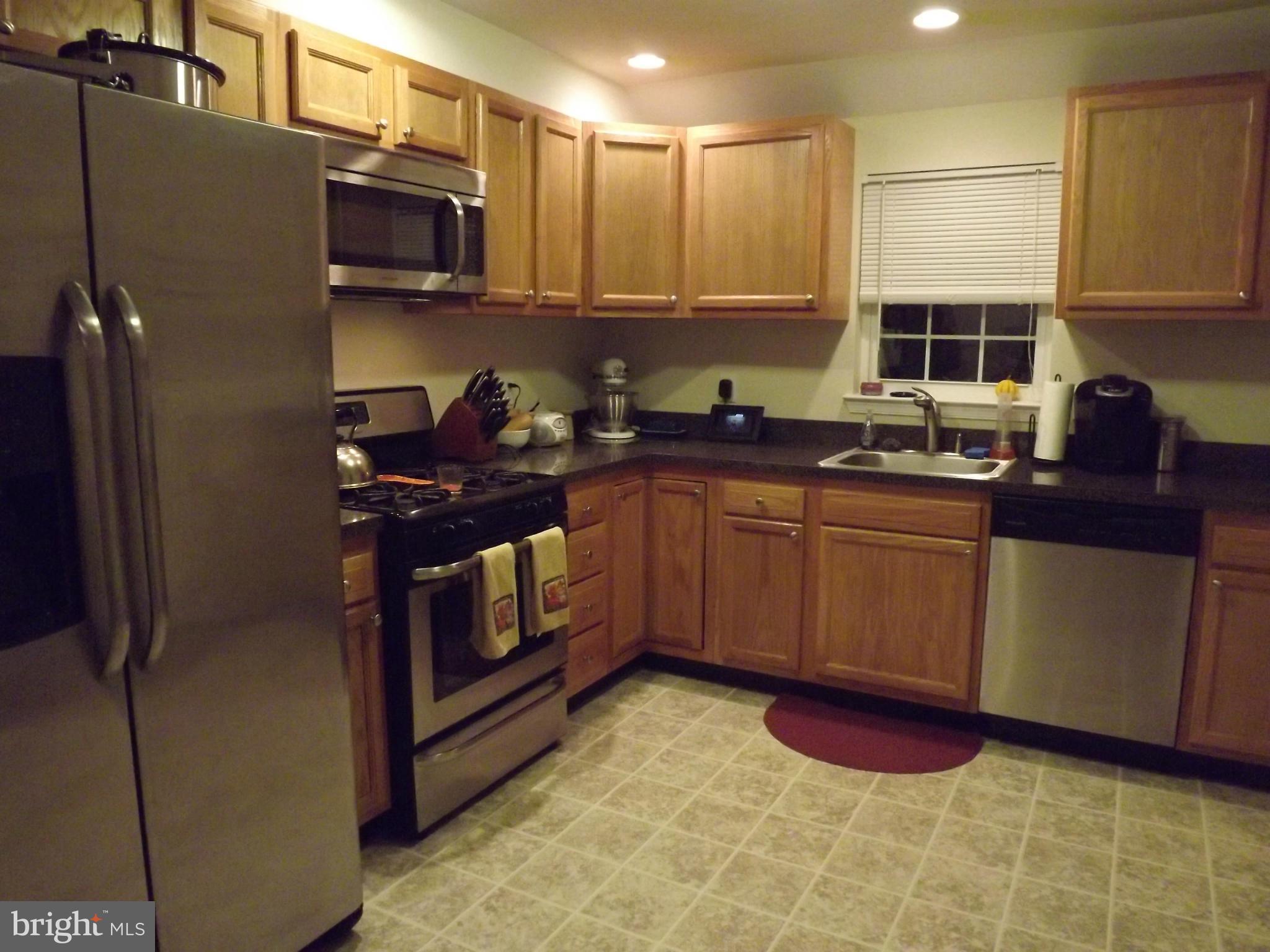 3167 Baybriar Road Baltimore, MD 21222 - Photo 17 of 30 a kitchen with stainless steel appliances granite countertop a stove a sink and a refrigerator