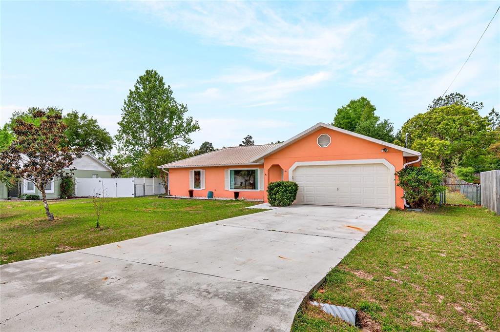 10 Almond Trace Ocala, FL 34472 - Photo 2 of 29 a front view of a house with a yard and garage