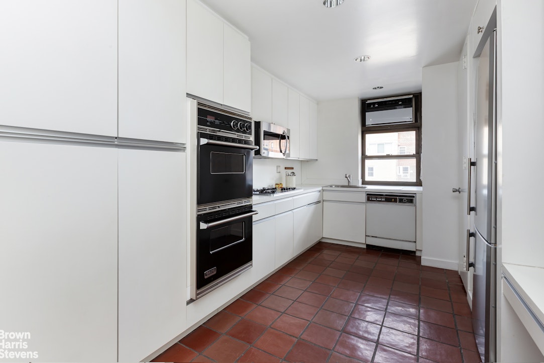 37 Riverside Drive, Unit 10B Manhattan, NY 10023 - Photo 14 of 25 a kitchen with a refrigerator sink and cabinets