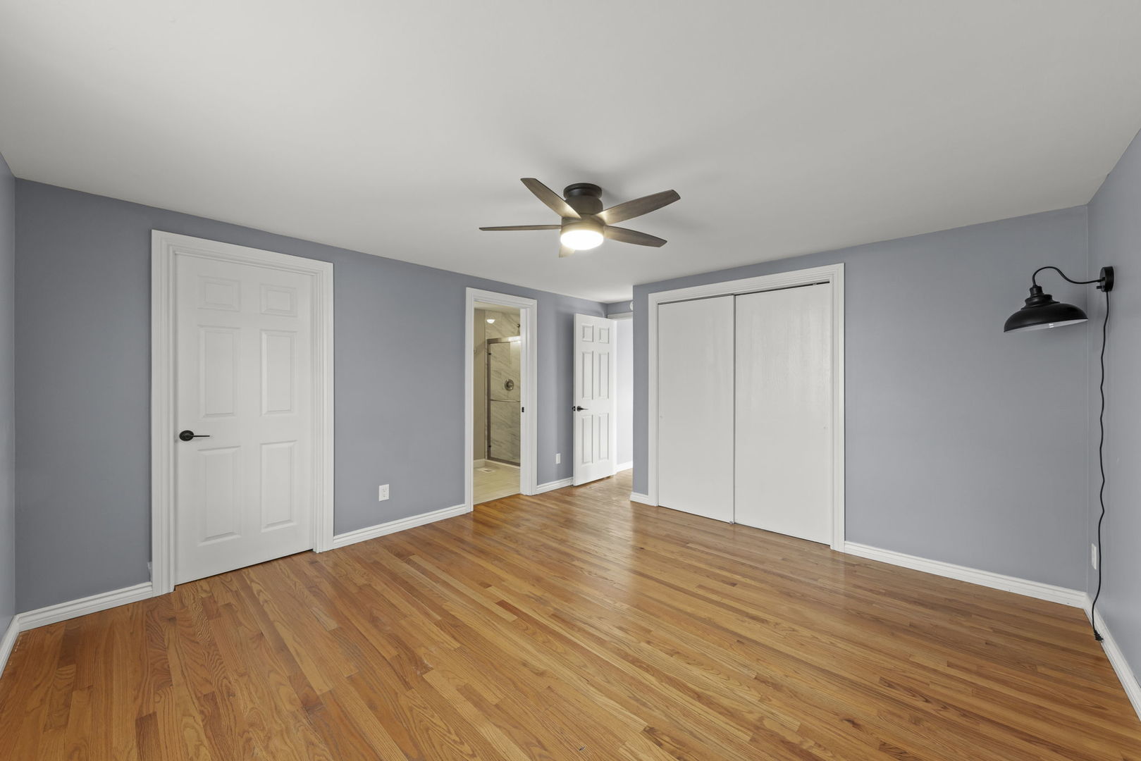 548 Jo Ann Court Lockport, IL 60441 - Photo 11 of 20 a big room with wooden floor and a ceiling fan