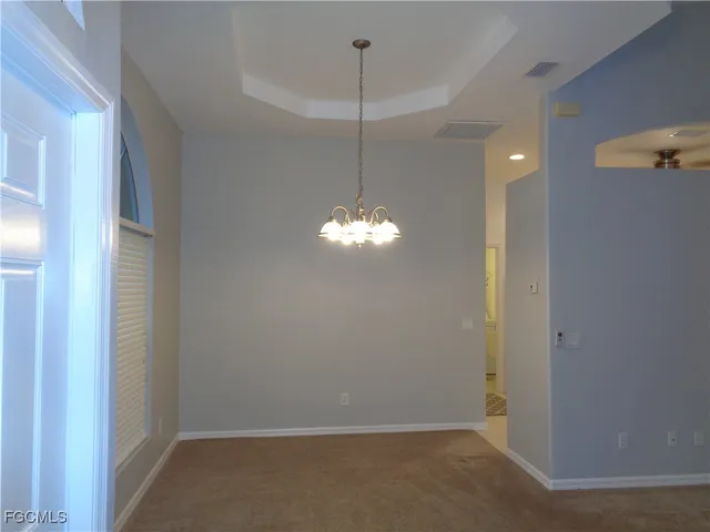 a room with a chandelier fan and a window