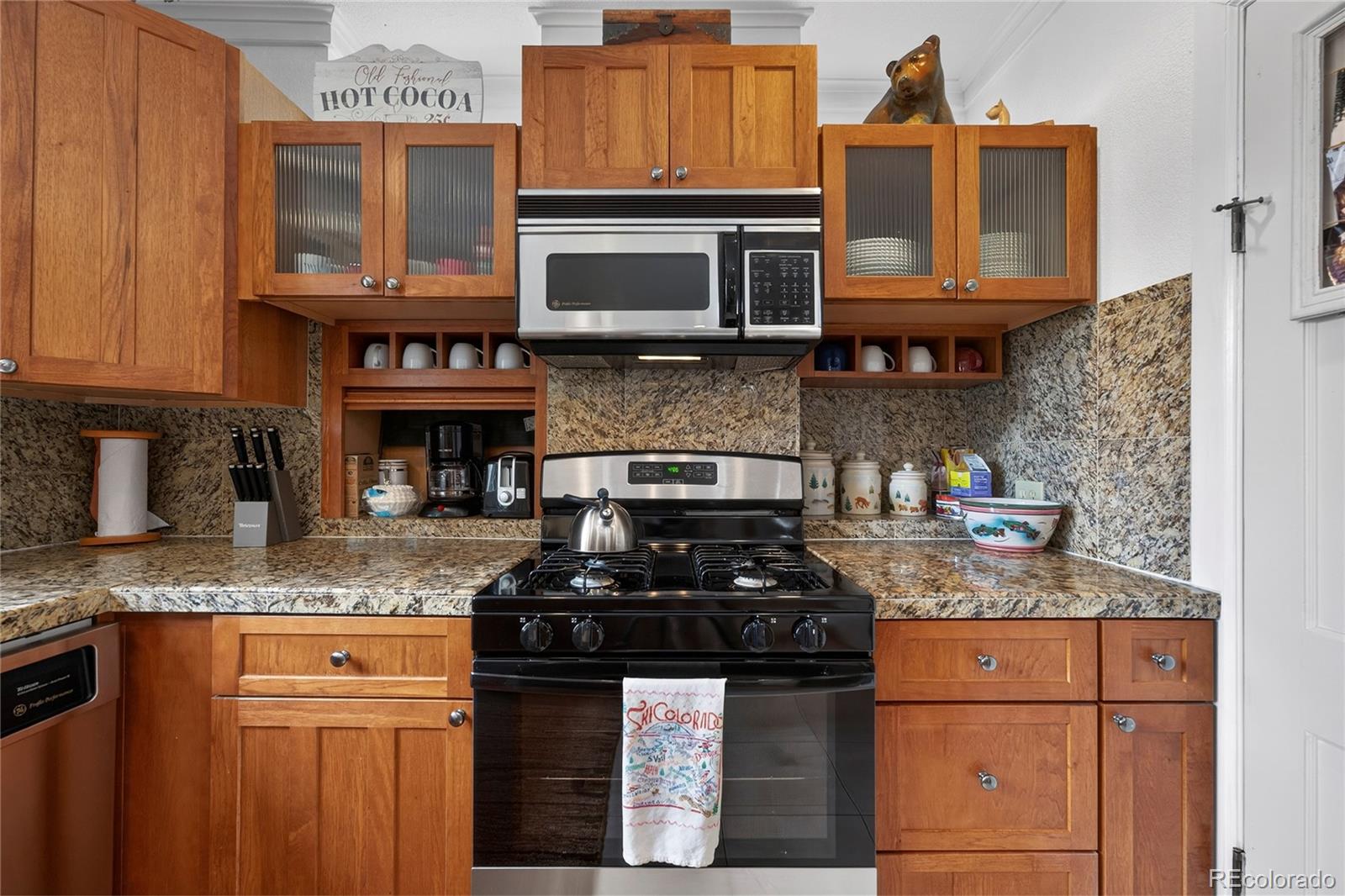 327 Vasquez Road, Unit E1 Winter Park, CO 80482 - Photo 33 of 43 a kitchen with granite countertop stainless steel appliances a stove a sink and a microwave