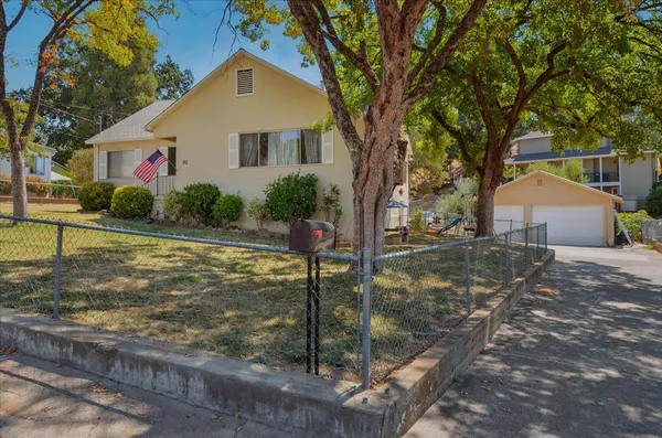 a front view of house with yard and trees in the background