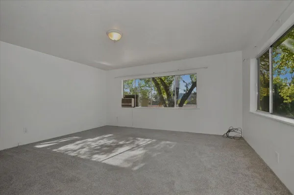 a view of a hallway to rooms and wooden floor