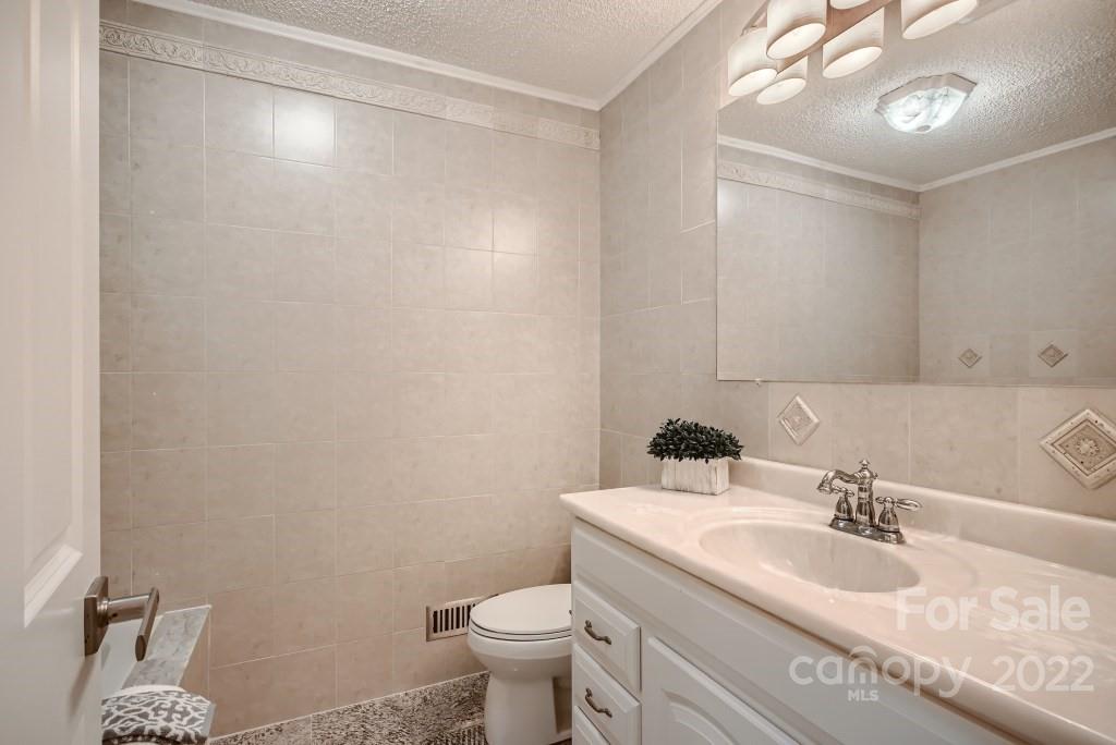 8000 Rising Meadow Road Charlotte, NC 28277 - Photo 23 of 28 a bathroom with a granite countertop sink a toilet and a mirror