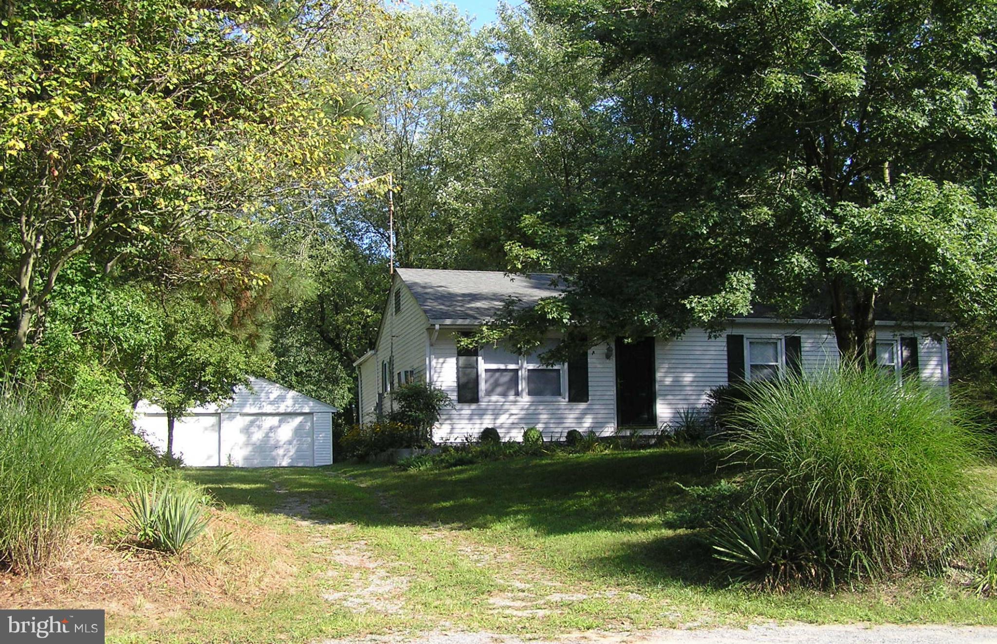 a front view of a house with a garden and plants