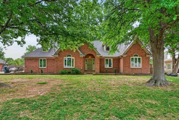 a front view of a house with yard and green space