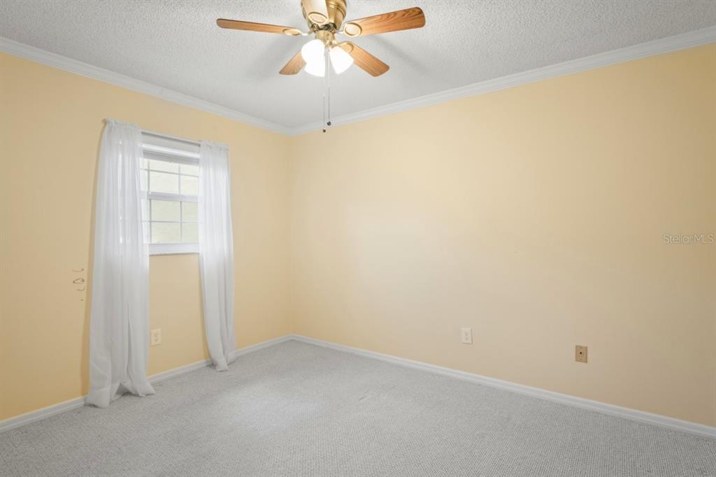 6702 Dartmoor Lane, Unit 7A New Port Richey, FL 34653 - Photo 12 of 40 an empty room with a window and a chandelier fan