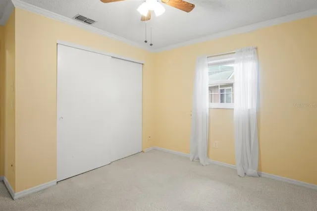 an empty room with a ceiling fan and a window
