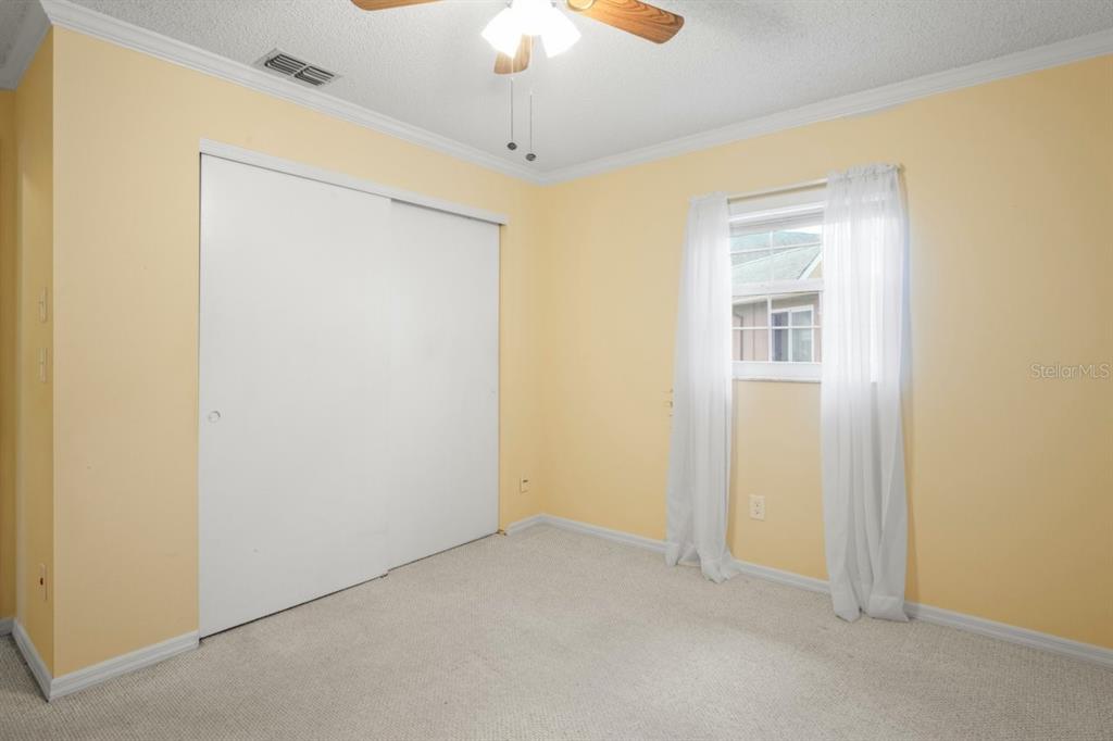 6702 Dartmoor Lane, Unit 7A New Port Richey, FL 34653 - Photo 13 of 40 an empty room with a ceiling fan and a window