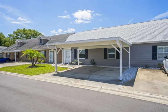 a view of yellow house with a large windows and a yard