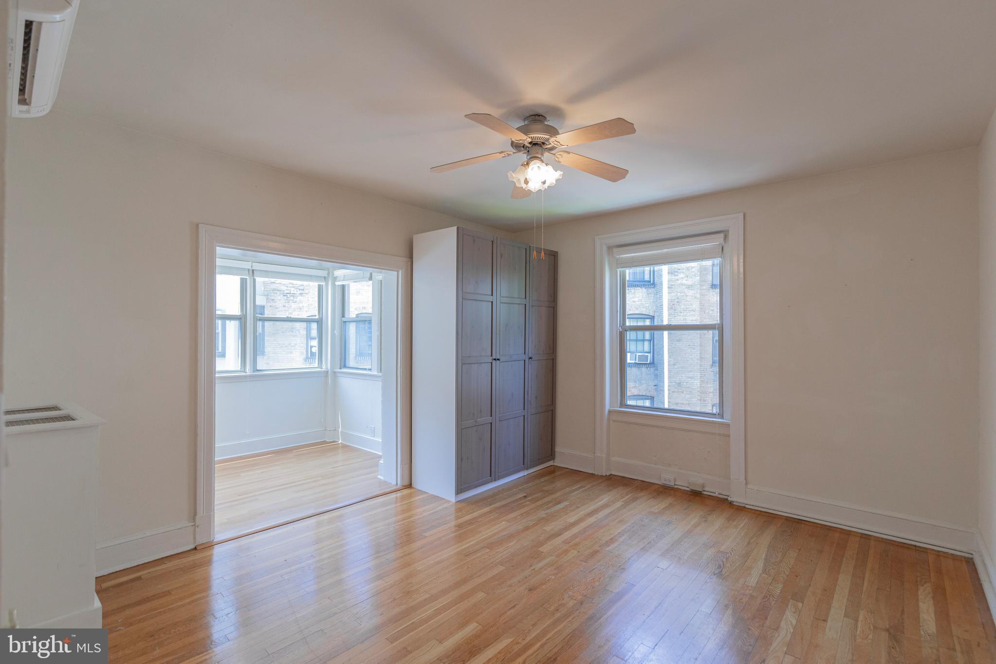 1910 Kalorama Road Northwest, Unit 307 Washington, DC 20009 - Photo 12 of 19 an empty room with wooden floor fan and windows